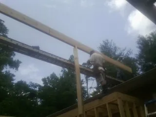 Carpenter setting a ridge beam over a new addition frame — Ice Dam Removal by Roofing Brothers in New Gloucester