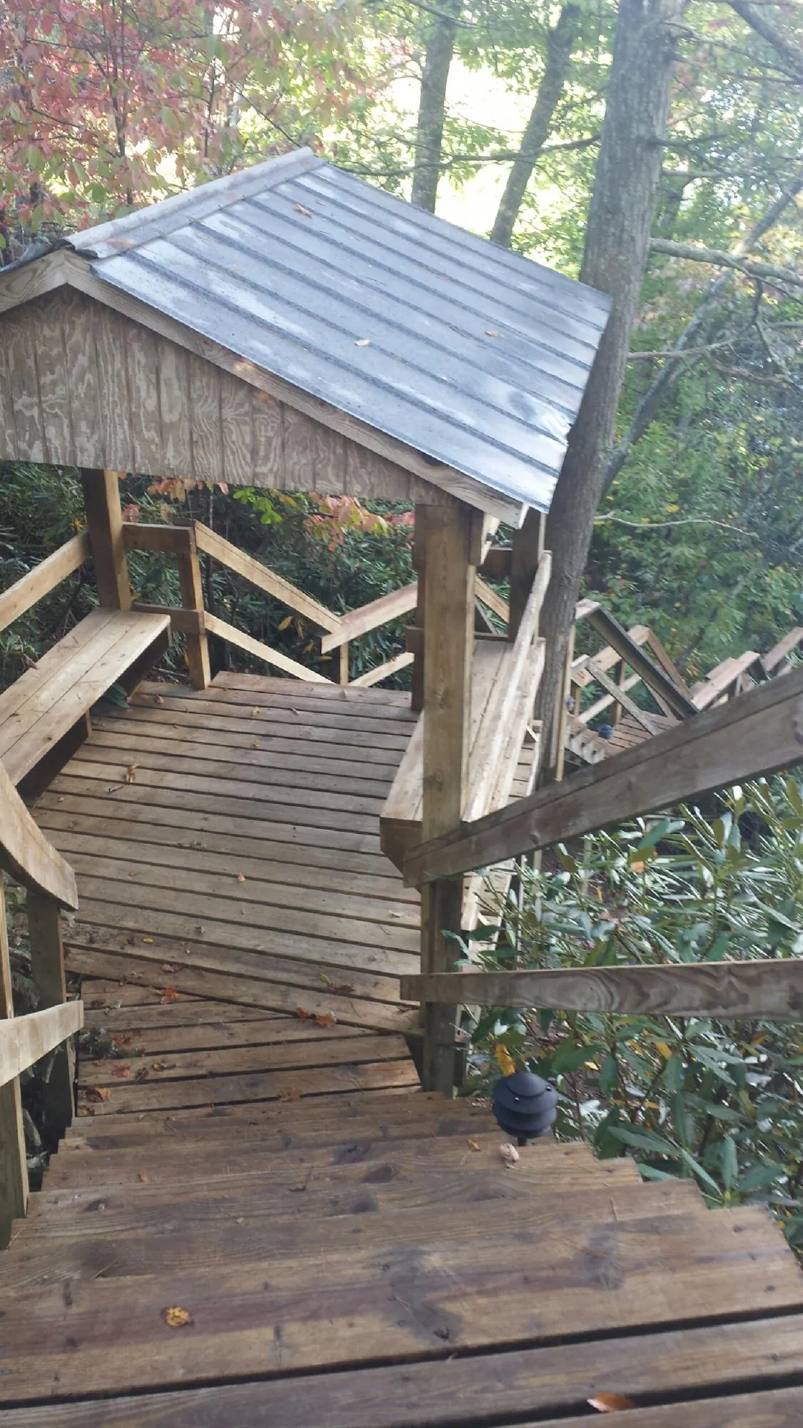 Metal roofed shelter over wooden steps on a wooded walkway — Skylight Repair & Installation work by our crew in New Gloucester