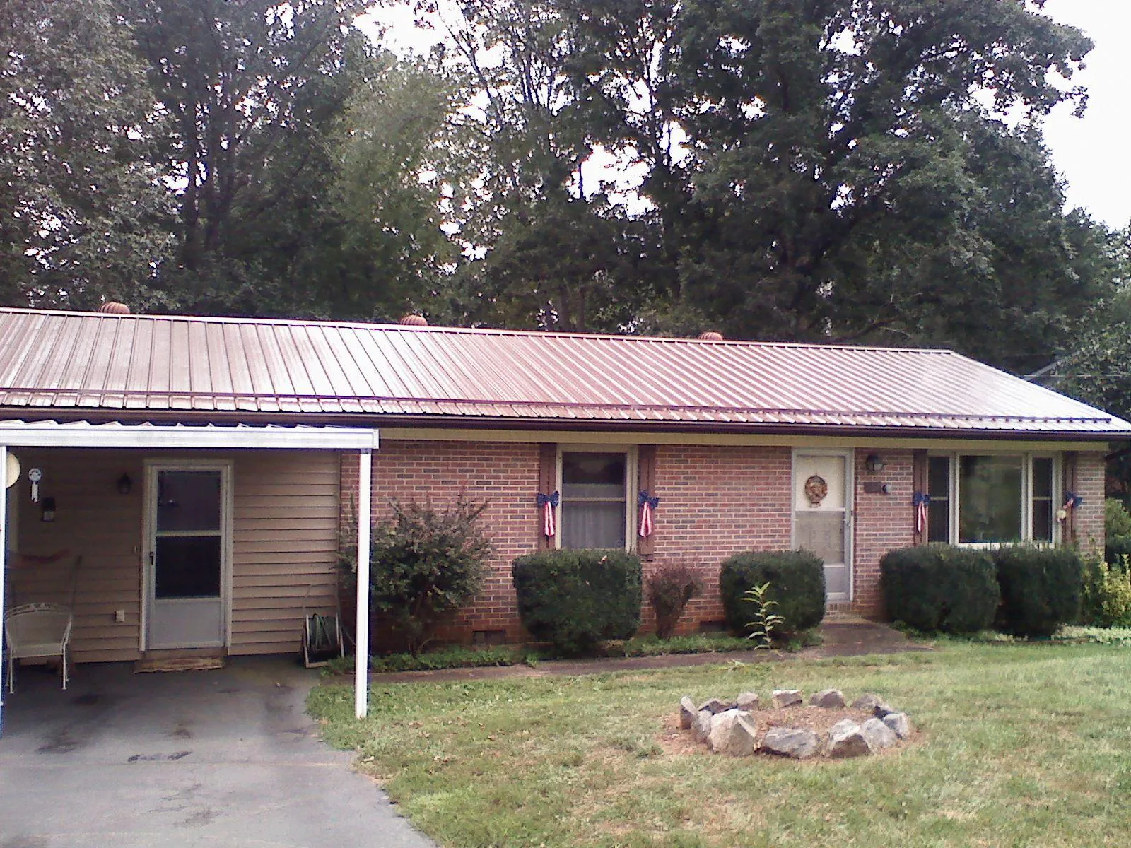 Bronze metal roof and carport on a brick ranch home — Roof Repair work by our crew in New Gloucester