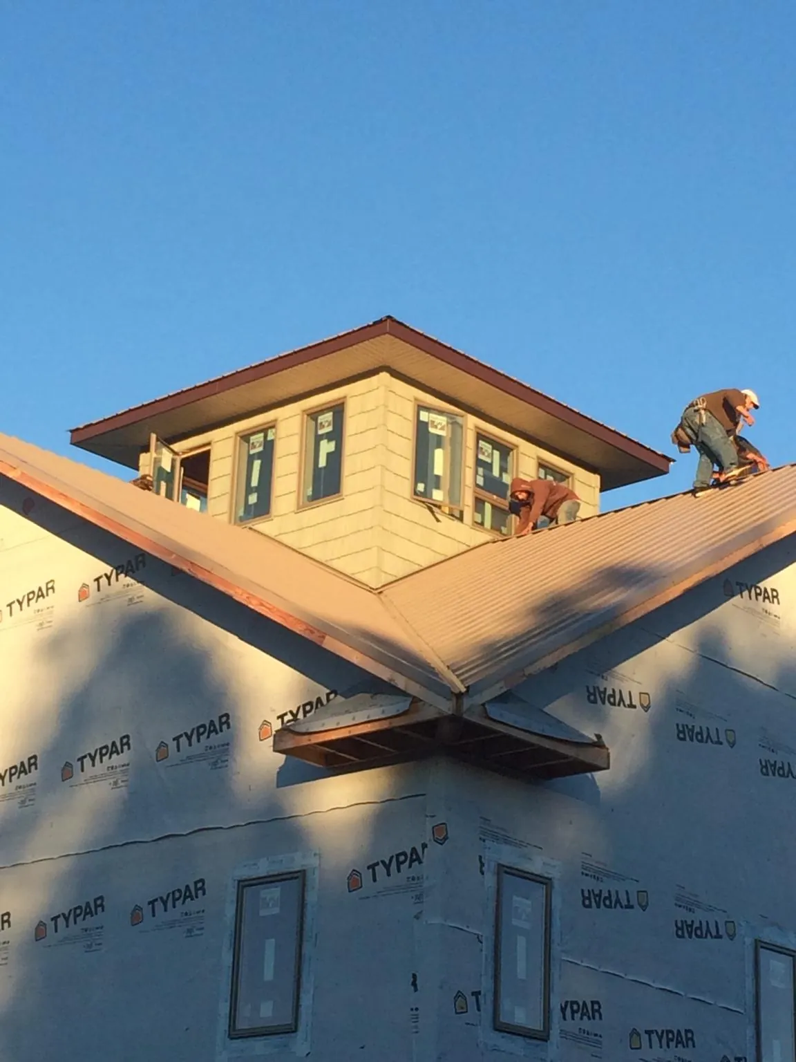 Roofers working around a rooftop cupola on a new metal roof at sunset — Roof Waterproofing in New Gloucester by Roofing Brothers